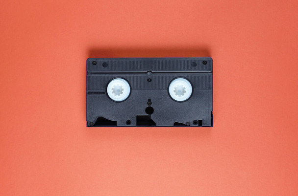 ポップカルチャーレトロな属性80年代、赤い背景のビデオカセット。トップ表示 - 写真・画像