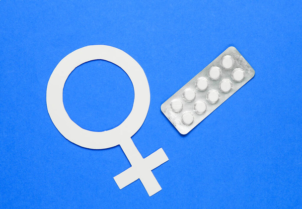 Women Health. Female gender symbol, pills on blue background. - Фото, зображення