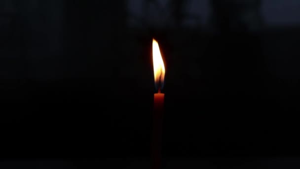 płomień płonącej świecy w ciemnym zbliżeniu - Materiał filmowy, wideo