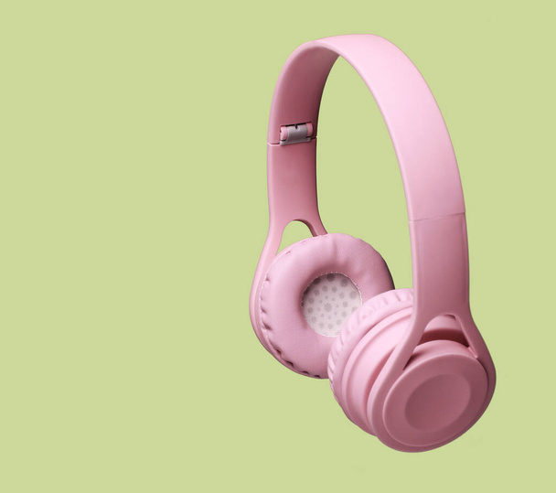 3D surround zdjęcie różowe bezprzewodowe słuchawki na zielonym tle. - Zdjęcie, obraz