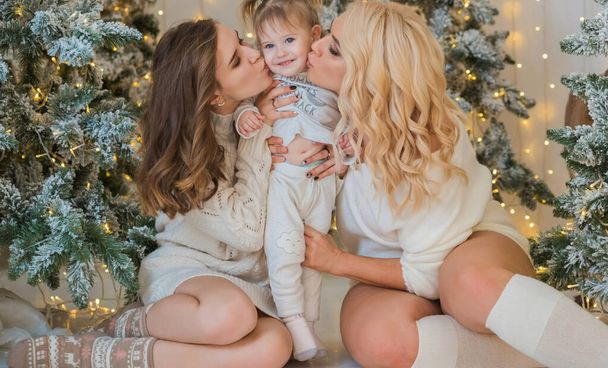 Χριστουγεννιάτικη οικογενειακή σκηνή, δύο γυναίκες με παιδί, ευτυχισμένες μαμάδες, Πρωτοχρονιά - Φωτογραφία, εικόνα