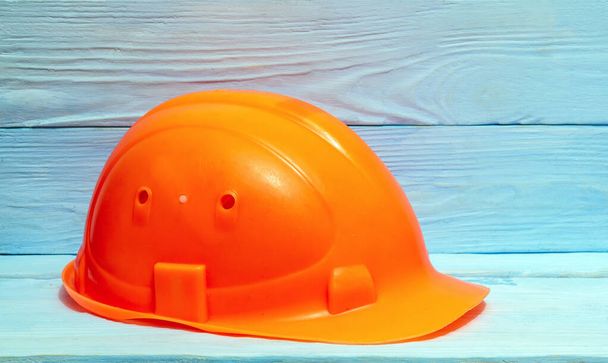 Construction orange helmet against the background of blue boards - Photo, Image