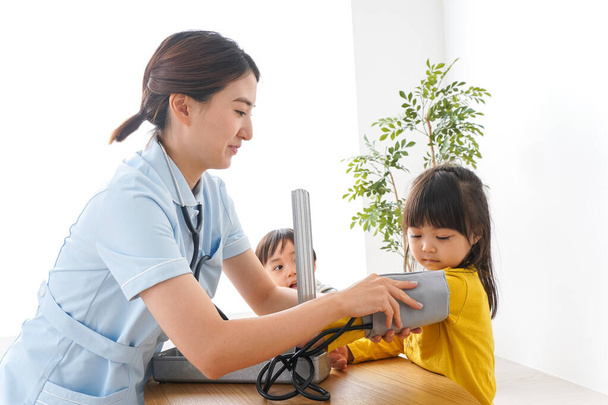Verpleegster en kinderen in kliniek - Foto, afbeelding