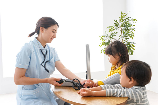 Verpleegster en kinderen in kliniek - Foto, afbeelding