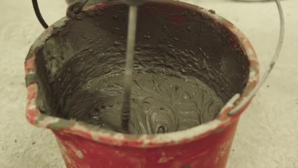 Η διαδικασία ανάμιξης τσιμεντοκονίας σε κουβά με μίξερ - Πλάνα, βίντεο