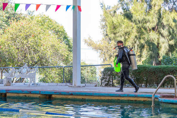 buceador caminando por la piscina después de su clase de buceo - Foto, Imagen