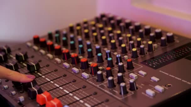 Sound producer hand is het gebruik van een muziek mixer met editing tools. De media. Close-up van vrouwelijke handdraaihefbomen van een mengpaneel, concept van muziekproductie. - Video