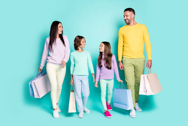 Photo portrait of full family with small kids holding shopping bags isolated on vivid teal colored background - Foto, Imagem