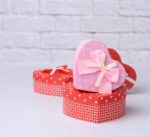 pila de varias cajas rojas con regalos sobre fondo blanco, telón de fondo festivo - Foto, imagen