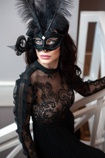 Een vrouw met een zwart masker op haar gezicht. Carnaval. Partij. - Foto, afbeelding