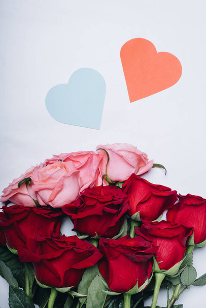 Bouquet of beautiful roses on a white background and two hearts. Top view - Foto, immagini