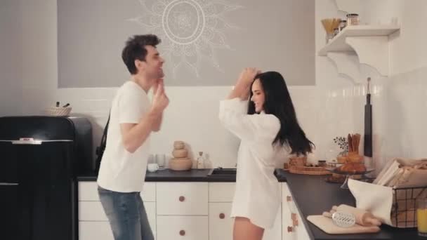 Aufgeregtes Paar tanzt gemeinsam in moderner Küche - Filmmaterial, Video