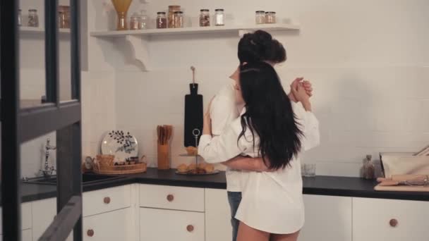 Lächelndes Paar umarmt sich beim Tanzen in der modernen Küche - Filmmaterial, Video