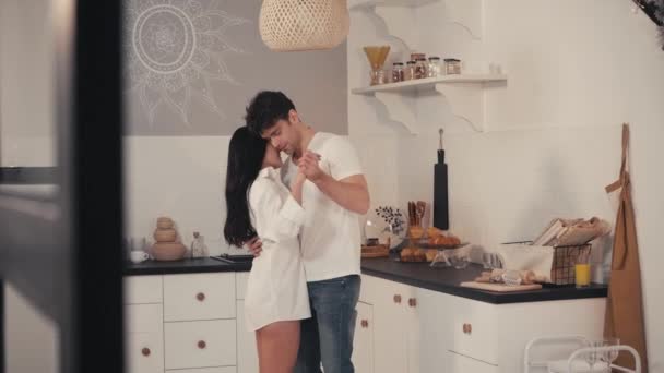 szczęśliwy para taniec z zamkniętymi oczami w kuchni, zamazany pierwszy plan - Materiał filmowy, wideo