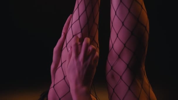 recortado vista de sexy mujer tocando las piernas en medias de rejilla  - Imágenes, Vídeo