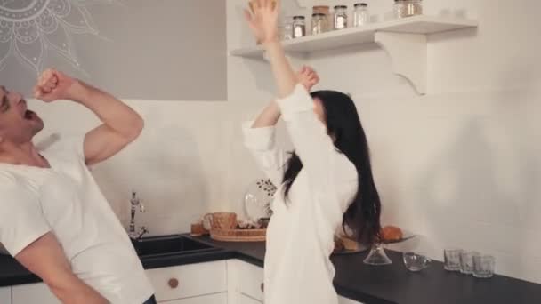 Fröhliches junges Paar tanzt morgens in moderner Küche - Filmmaterial, Video
