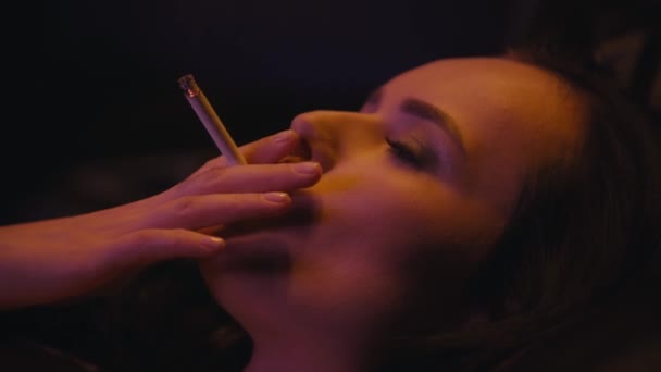 młoda brunetka kobieta palenie papierosów na czarny  - Materiał filmowy, wideo