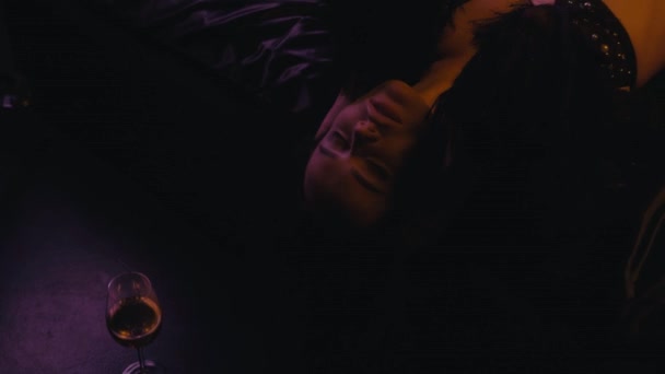 mujer seductora en sujetador acostado en ropa de cama de satén cerca de un vaso de vino blanco - Metraje, vídeo