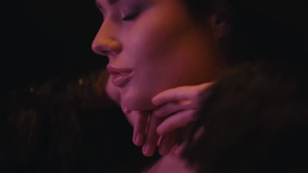 sexy kobieta z zamkniętymi oczami dotykając twarzy i szyi odizolowany na czarny - Materiał filmowy, wideo