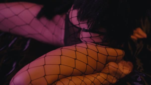 sexy woman in fishnet tights touching body on dark background - Footage, Video