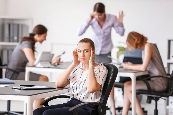 Стрессовая женщина с головной болью и шумными людьми в офисе - Фото, изображение