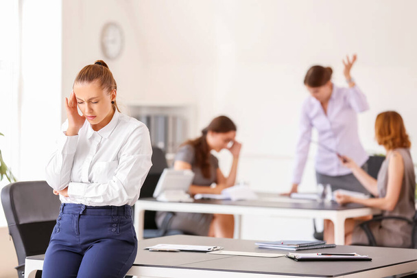Mulher estressada com dor de cabeça e pessoas barulhentas no escritório - Foto, Imagem