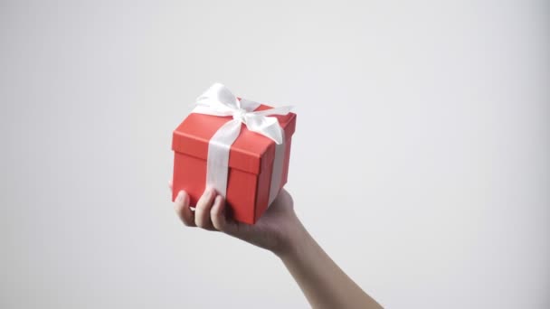 bambini mano tiene regalo rosso con nastro. natale, anno nuovo, sorpresa di compleanno - Filmati, video