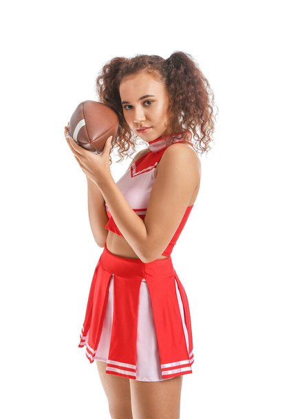 Beautiful young cheerleader with ball on white background - Foto, Bild