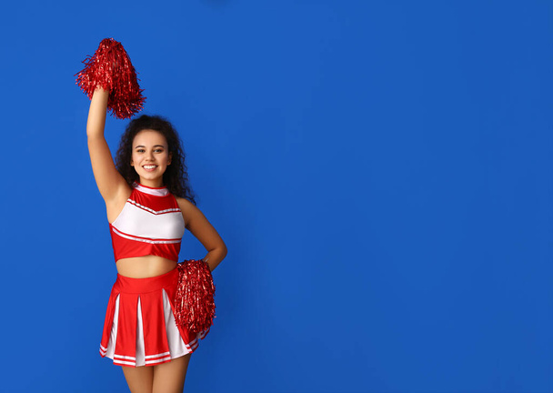 Piękna młoda cheerleaderka na tle koloru - Zdjęcie, obraz