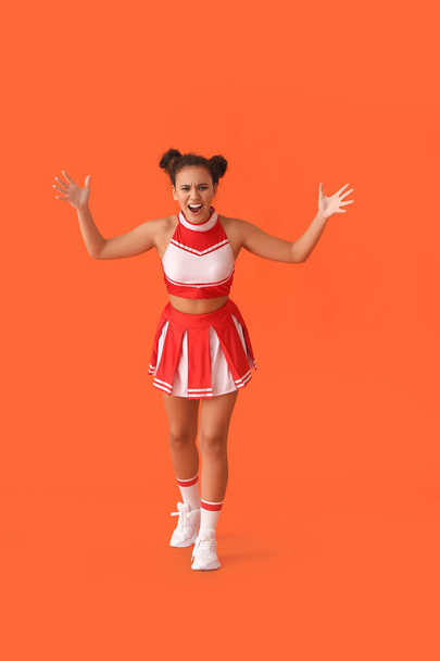 Emotional cheerleader on color background - Photo, image