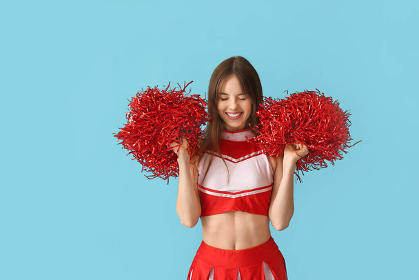 Beautiful young cheerleader on color background - Photo, Image