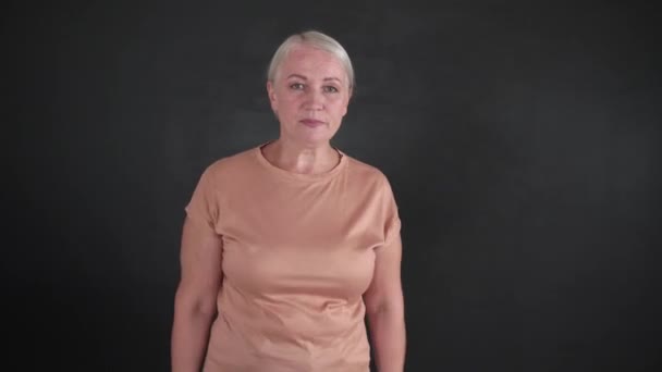 Στρεσαρισμένη ώριμη γυναίκα σε σκούρο φόντο - Πλάνα, βίντεο
