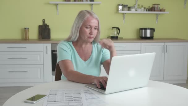 gespannen volwassen vrouw met laptop in keuken - Video