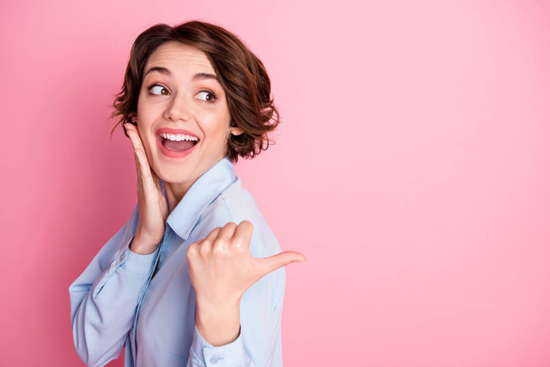 Profile photo of attractive funny cheerful lady direct finger side empty space show novelty sale shopping banner low price wear blue office shirt isolated pink pastel color background - 写真・画像