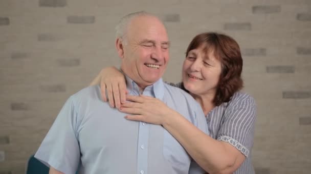 Fröhliches älteres erwachsenes Familienpaar, das sich umarmt, lacht, in die Kamera blickt. - Filmmaterial, Video