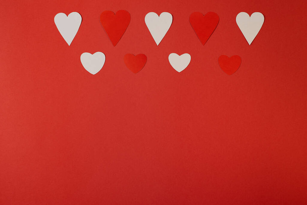 Papírové srdce nad červeným pozadím. Abstraktní pozadí s tvary střihu papíru. Svatý Valentýn, Den matek, přání k narozeninám, pozvánka, koncepce oslav - Fotografie, Obrázek