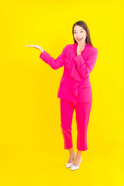 Portrait beautiful young asian woman smile in action on yellow color background - Foto, Imagem