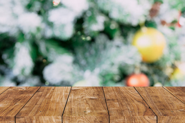 Rozmazat vánoční strom s dřevěným stolem popředí pro reklamní pozadí - Fotografie, Obrázek