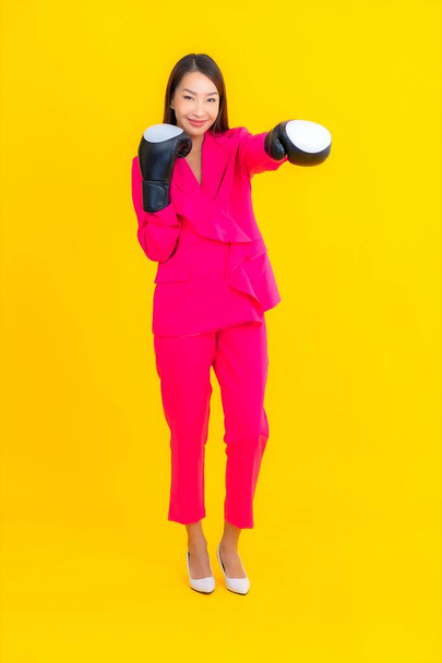 Portrait beautiful young asian woman with boxing on yellow isolated background - Foto, Bild