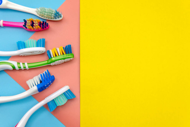 Colorful toothbrushes on a colored background, place for text - Foto, Imagen