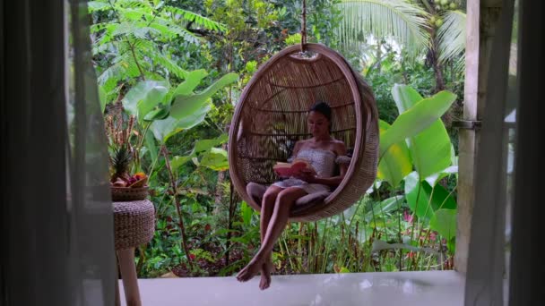 une fille est assise dans un hamac suspendu, avec un livre, Bali - Séquence, vidéo