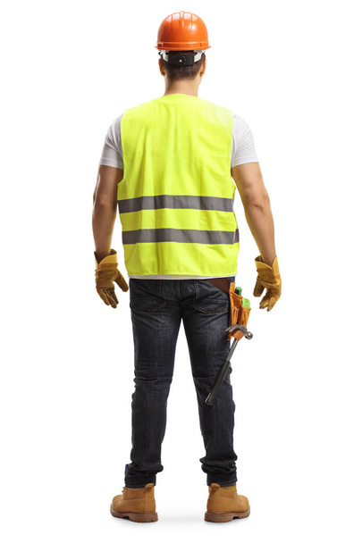 Full length back shot of a construction worker with a helmet and a vest isolated on white background - Fotoğraf, Görsel