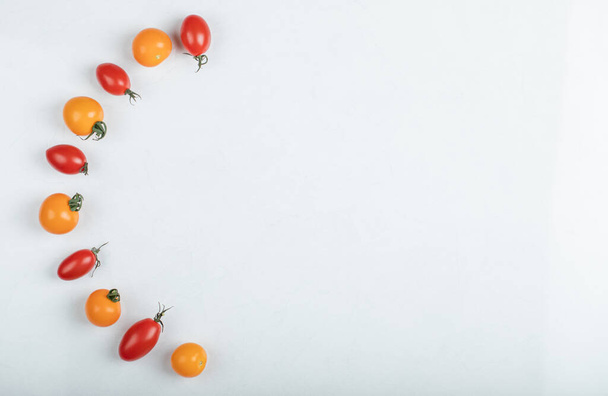 Wide angle Gleaming red and yellow tomatoes on white background - Foto, Imagen