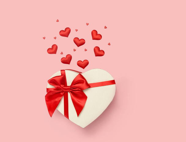 Valentines Day pozadí. Dárková krabička v podobě srdce s červenou mašlí na růžové .background Mezinárodní den žen, 8 března, narozeniny, svatba, koncept lásky. Byt ležel, horní pohled, kopírovací prostor - Fotografie, Obrázek