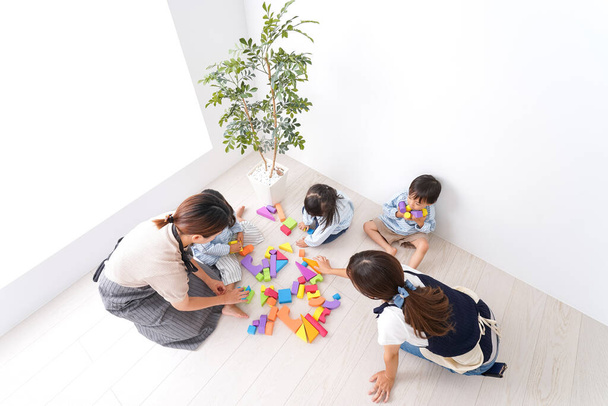 Kinderen en leraar spelen met speelgoed  - Foto, afbeelding