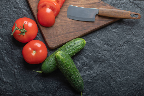 Fresh vegetables cucumber and tomato on black background - Fotó, kép