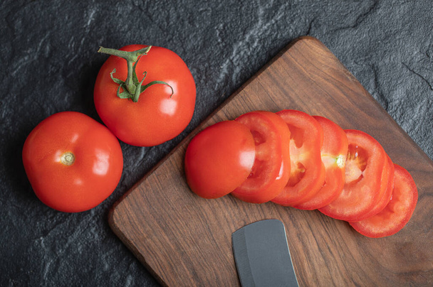 Close up view of freshly picked, juicy tomatoes on dark stone background - Foto, Imagem