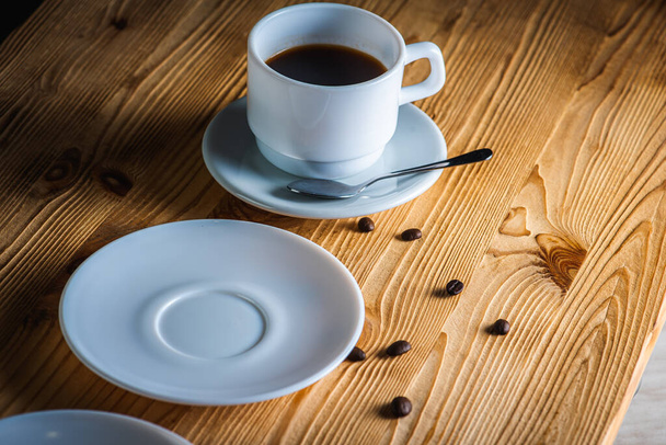 крупним планом, чашка білої кави з чайними тарілками на дерев'яній поверхні з простором. Концепція ранкової кави
 - Фото, зображення
