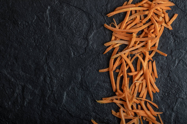 Julienne of fresh organic carrot over black background - Photo, Image