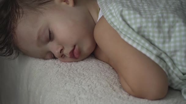 リラクゼーション、甘い夢、子供時代、家族の概念-タイトなクローズアップリトル2歳の未成年の未成年の幼児ウェットベビーボーイランチタイム睡眠モードでダークルームの毛布に覆われた白いベッドで寝る - 映像、動画